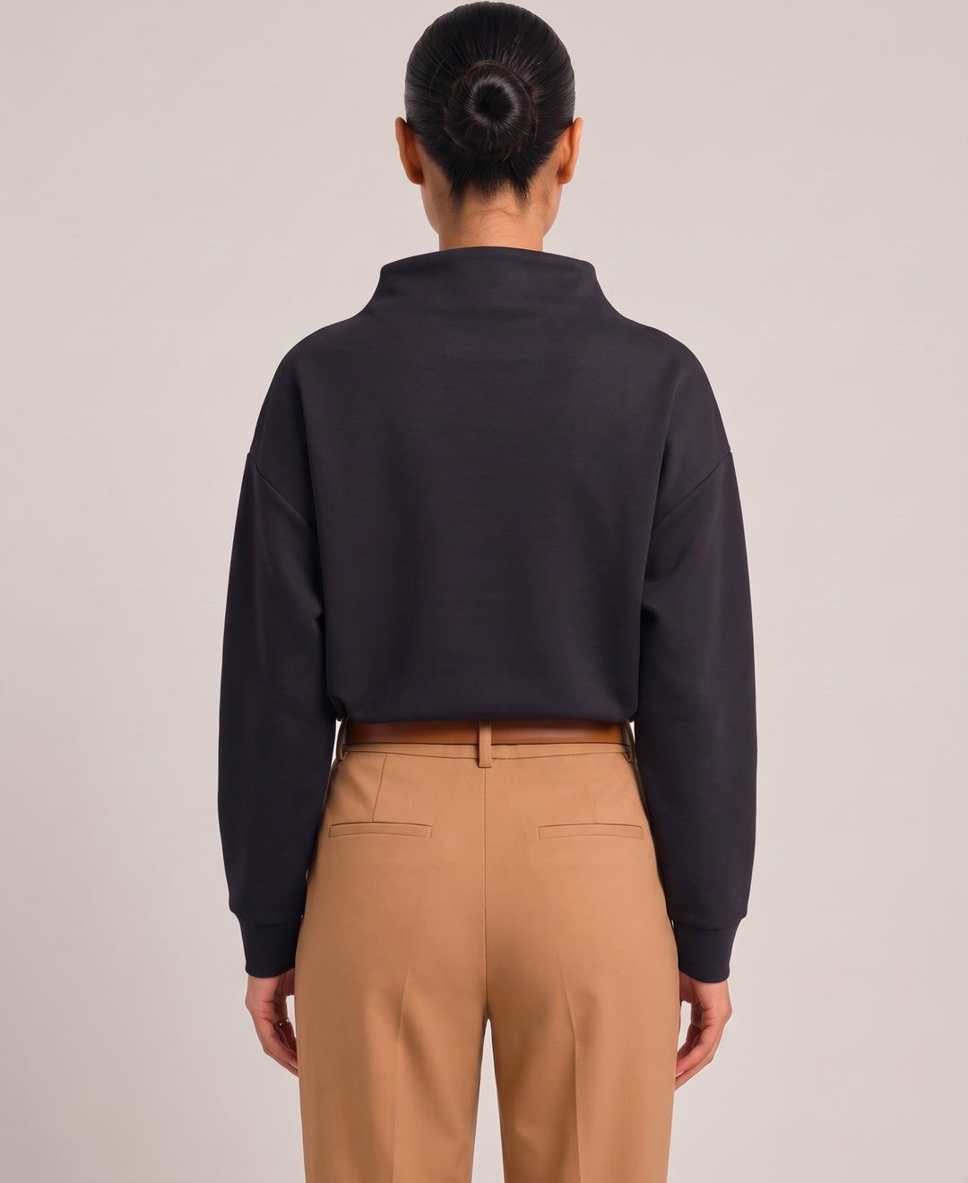 Women's oversized funnel neck top in black, back view