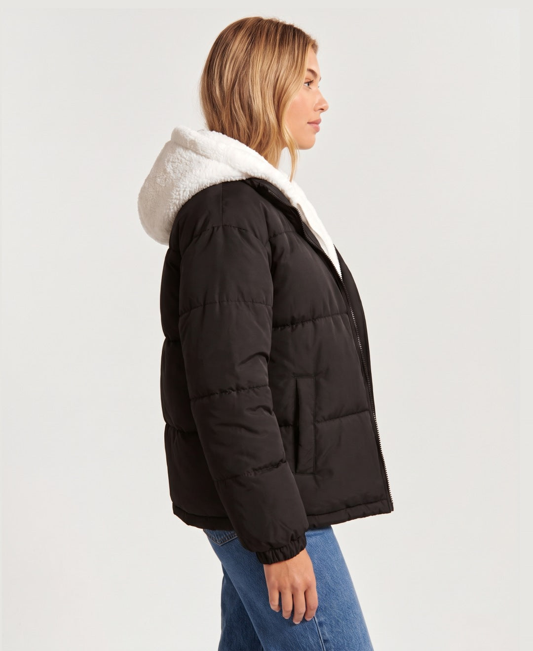 Women's hooded puffer jacket with sherpa fleece hood in black, side view