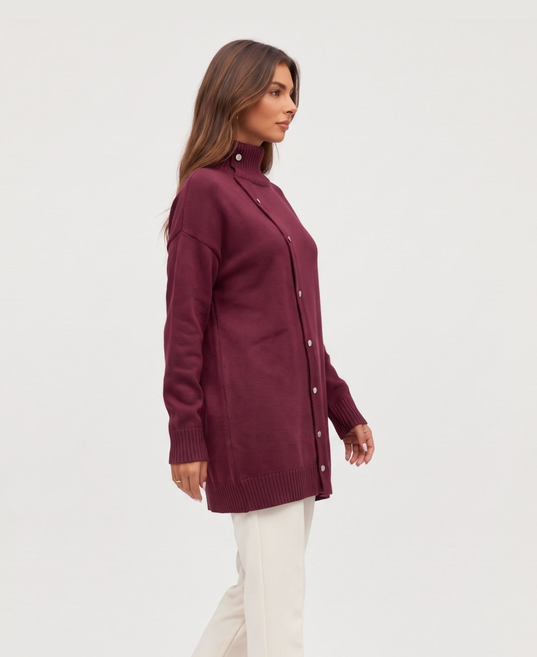 Women's longline roll neck jumper with asymmetric buttons in burgundy, side view